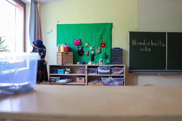 An einer Wand hängen kleine handgenähte Tiere und Sterne und Taschen.