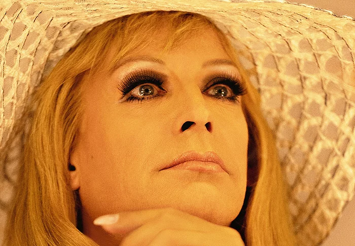 Tim Fischer in seiner Rolle als Hildegard Knef, mit Langhaarperücke und einem großen hellen Sommerhut