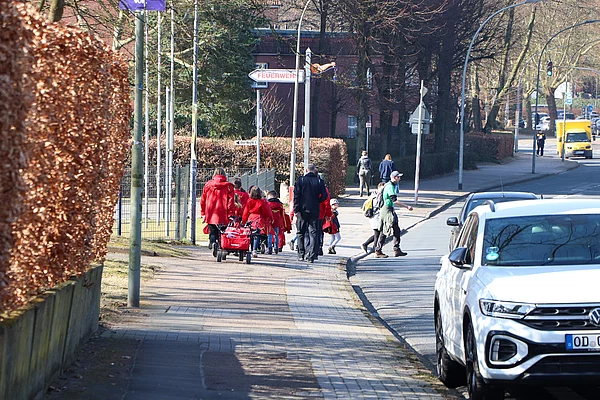 Eine Kindergruppe geht einen Weg entlang.