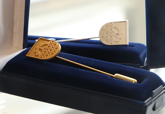 Eine Ehrennadel der Stadt Glinde in Gold ist eine Darstellung des Wappens.