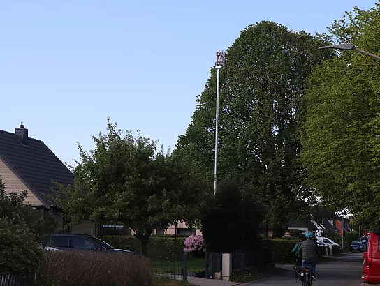 Die Straße "Am Anger", im Hintergrund eine Sirene auf einem Mast.