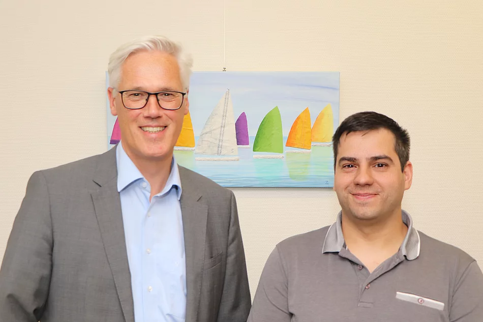 Bürgermeister Rainhard Zug mit Araels Diass, der seine Ausbildung zum Verwaltungsfachangestellten abgeschlossen hat.