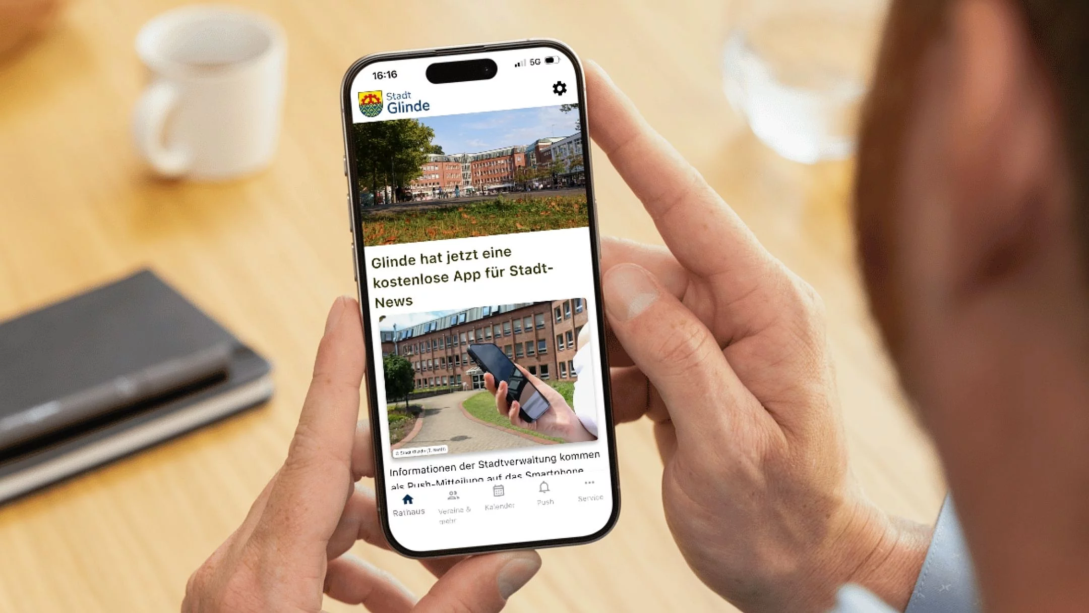 Die geöffnete "Stadt Glinde"-App auf einem Smartphone in der Hand eines Mannes.
