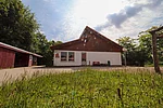 Ein weißes Gebäude mit spitzem braunem Dach. 