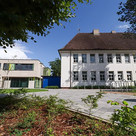 Links ist die neue Mensa der Grundschule Tannenweg und rechts das alte Schulgebäude.