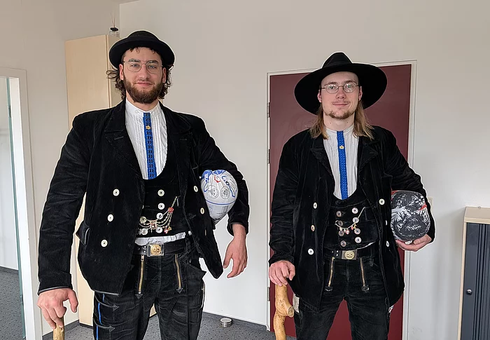 Zwei Männer in schwarzer Zimmermann-Kluft stehen nebeneinander.