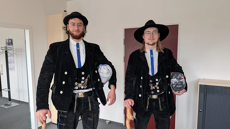 Zwei Männer in schwarzer Zimmermann-Kluft stehen nebeneinander.