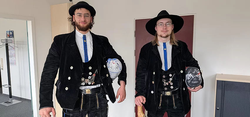 Zwei Männer in schwarzer Zimmermann-Kluft stehen nebeneinander.