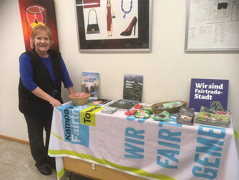Ulrike Müller-Kopsch steht an einem Fairtrade-Informationsstand.