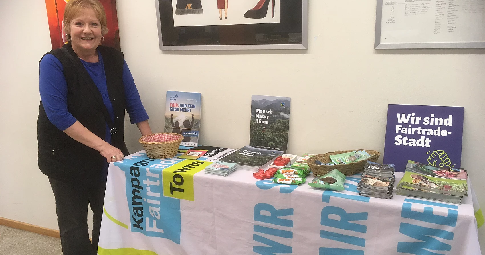 Ulrike Müller-Kopsch steht an einem Fairtrade-Informationsstand.