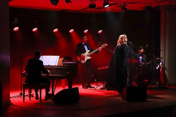 Tim Fischer steht auf der rot beleuchteten Bühne