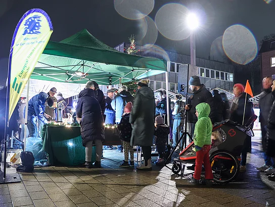 An einem Getränkestand stehen Menschen.
