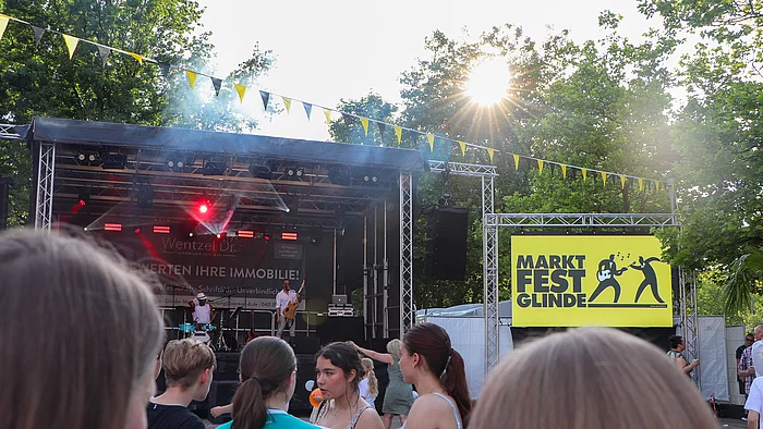 Blick zur Marktfestbühne, davor Publikum, recht eine Leinwand mit Marktfest-Logo
