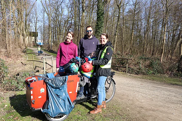 Eine Gruppe steht an einem Lastenrad mit Müllbeuteln.