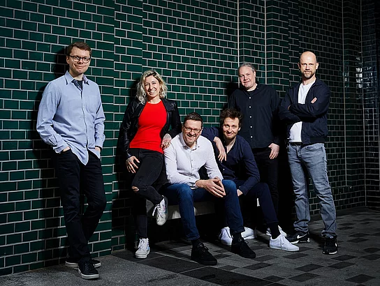 Die Band "FREESTYLE" spielt beste Coverhits Fünf Männer und eine Frau stehen zusammen an einer gefliesten Wand für ein Bandfoto.