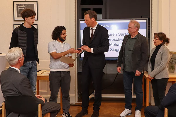 Claus Peters mit drei weiteren Männern und einer Frau bei der Ehrung.