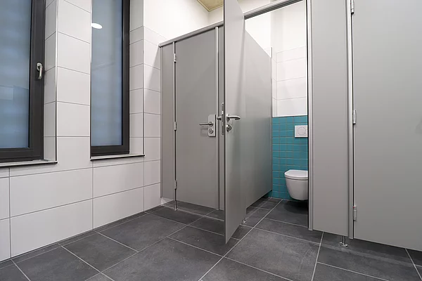 An einer Toilettenkabine steht die Tür offen.
