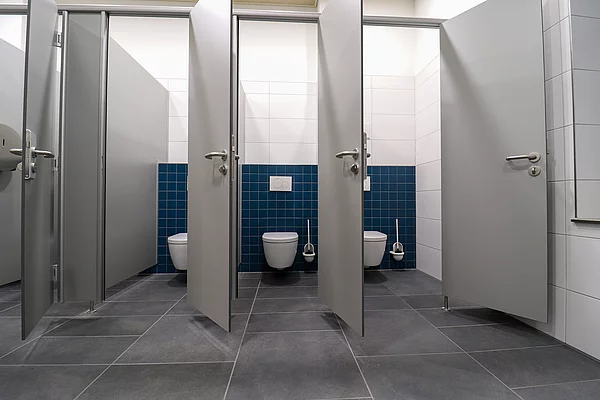 Geöffnete Türen von Toilettenkabinen.