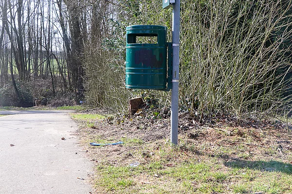 Ein grüner Mülleimer.