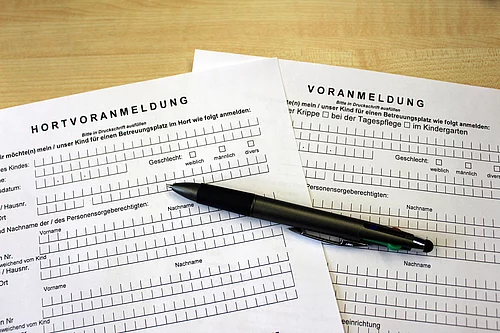 Auf Formularen liegt ein Kugelschreiber