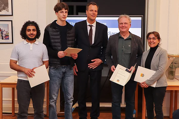 Fünf Personen stehen für ein Gruppenfoto nebeneinander.