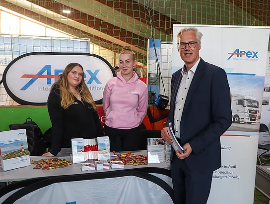 Menschen an einem Messestand der Firma APEX aus Glinde