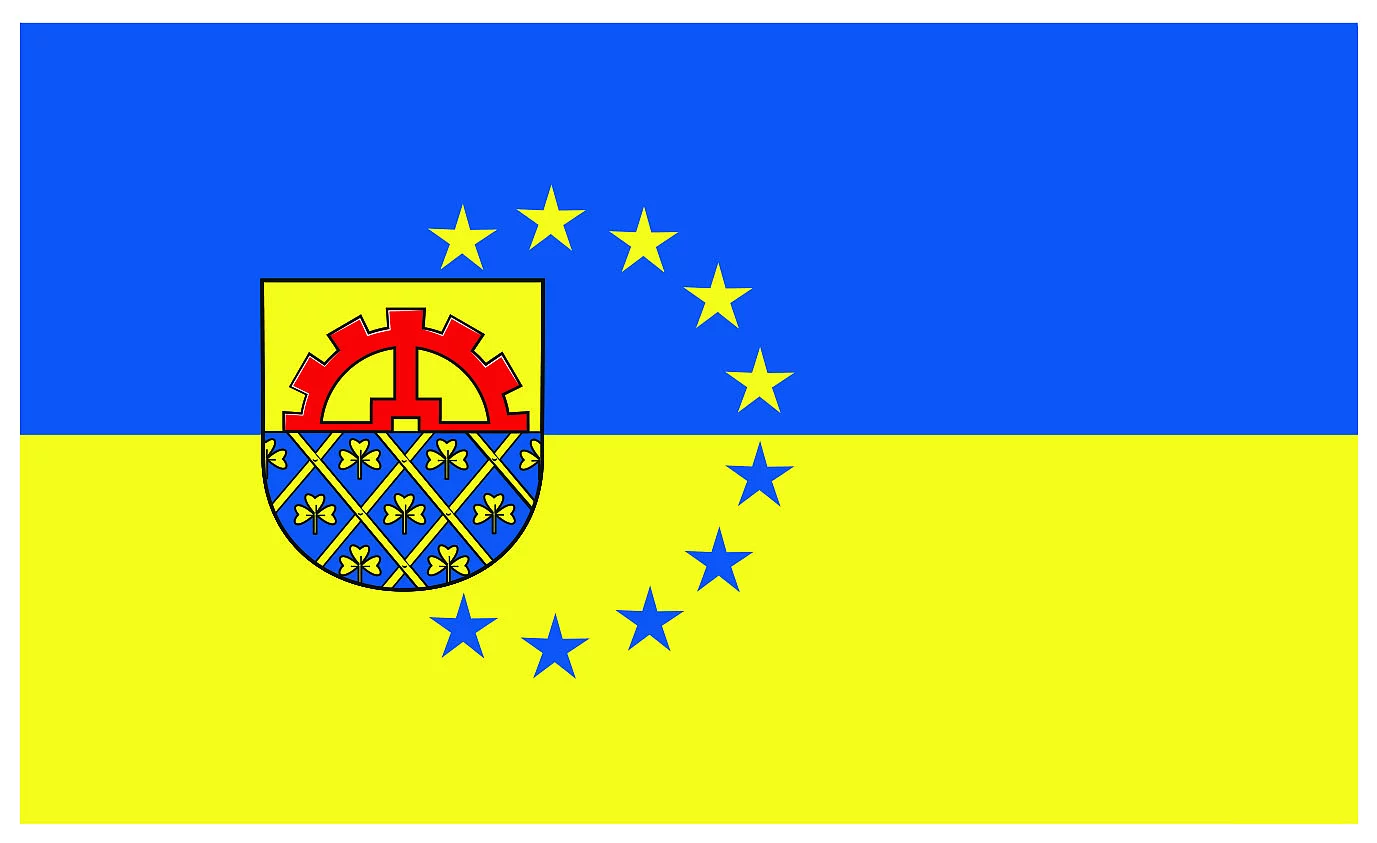 Die Glinder Flagge zeigt das Wappen mit Mühlenrad oben, Lattenzaun unten und dreiblättrige Kleeblätter. Die Flagge ist horizonal zweigeteilt. Oben blau unten gelb. Das Wappen umgeben 10 Sterne.