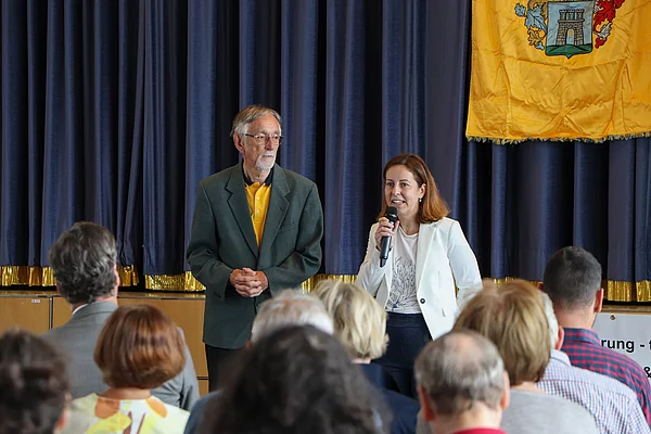 Ein Mann und eine Frau sprechen zum Publikum.