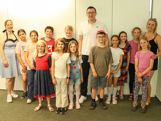 Viele Kinder, zwei Erzieherinnen und Bürgermeister Patrick Klose stehen für ein Gruppenfoto zusammen.