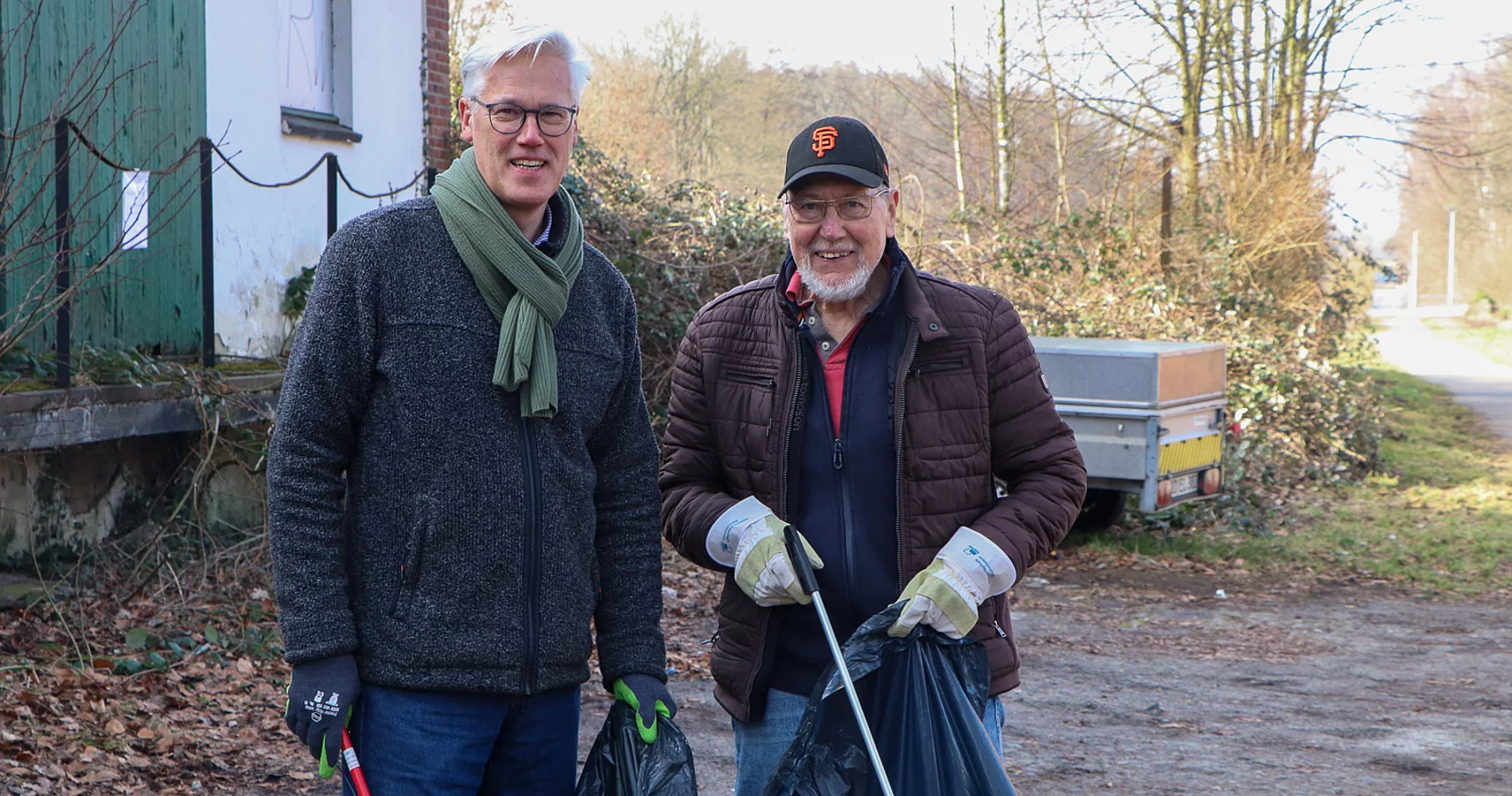 Bürgermeister Rainhard Zug und Wolfgang Funk mit Müllzange und Müllsack.