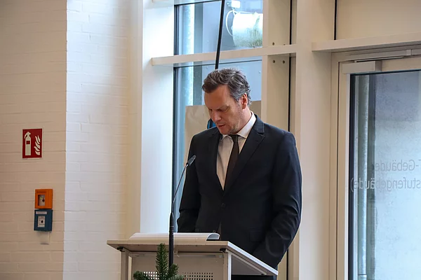 Bürgervorsteher Claus Peters an einem Rednerpult mit gesenktem Kopf.