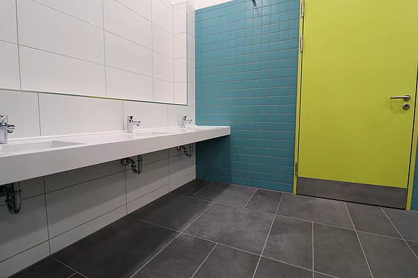Mehrere Waschbecken in einer Toilette nebeneinander.