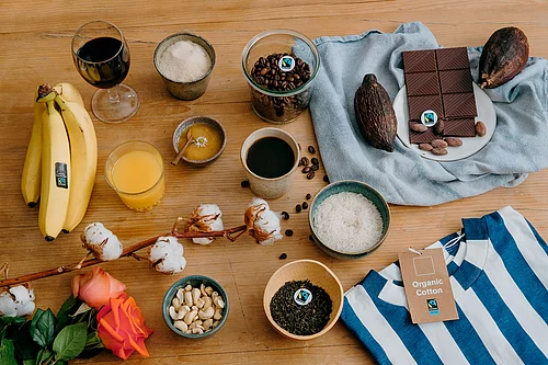 Auf einem Tisch liegen Bananen, Kaffee, Schokolade und weitere Fairtrade-Produkte.