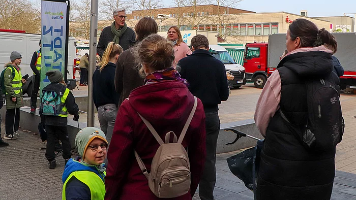 Vor dem Bürgerhaus stehen Menschen und warten auf den Start des STADTPUTZES.