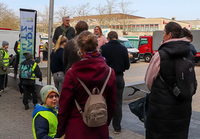 Vor dem Bürgerhaus stehen Menschen und warten auf den Start des STADTPUTZES.