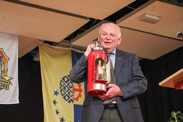 Lothar Neinass hat für das Amt Glinde gearbeitet und überreicht den Heiligen Antonius, der in einem offenen Feuerlöscher steht. Foto: Stadt Glinde