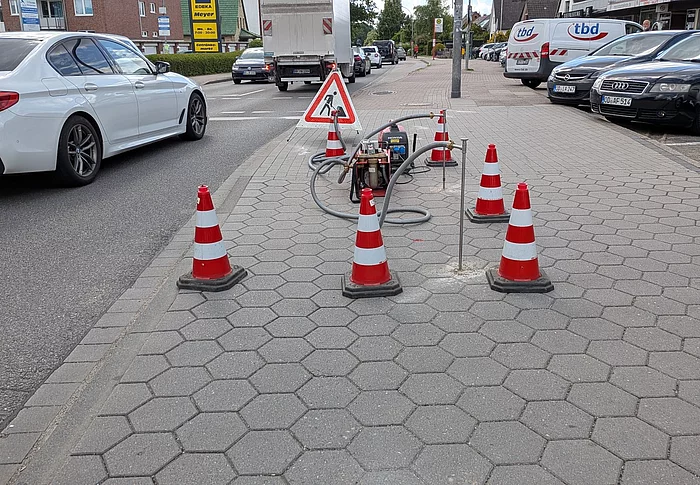 Absperrpylone stehen auf einem Gehweg.