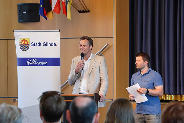 Bürgervorsteher Claus Peters spricht in ein Mikrofon vor Gästen. 