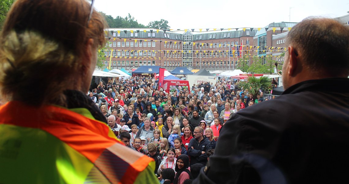 Marktfest-Organisatorin Tanja Woitaschek (l.) und DJ Raik Hennig (r.) geben die Gewinnerinnen und Gewinner der Laufkarten-Aktion bekanntgegeben. Foto: Stadt Glinde