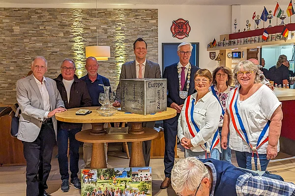 Eine Gruppe Menschen steht an einem Tisch. 