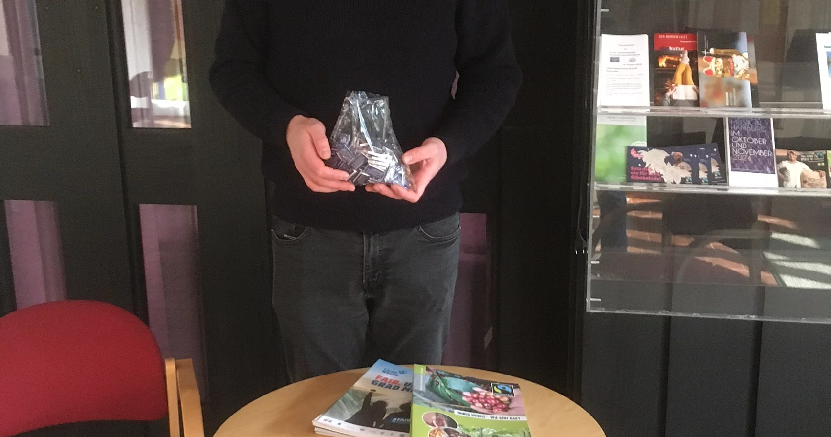 Pastor Nils Jacobsen von der St. Johannis Gemeinde mit Fairtrade-Schokolade und Info-Flyern.
