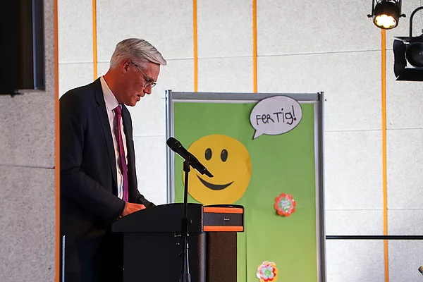 Bürgermeister Rainhard Zug vor einem Schild mit der Aufschrift "Fertig"