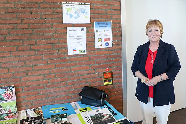 Eine Frau steht neben einem Informartionsstand.