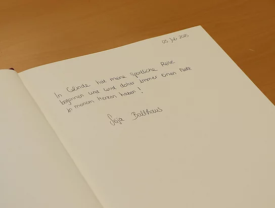 Auf einer Buchseite steht "In Glinde hat meine sportliche Reise begonnen und wird daher immer einen Platz in meinem Herzen haben!"