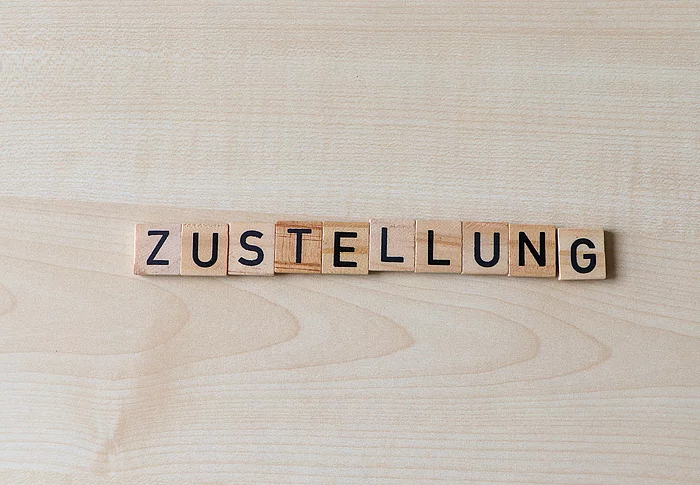Mit Holzplättchen wurde das Wort Zustellung gelegt.