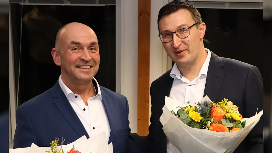 Zwei Männer halten Blumensträuße und lächeln.