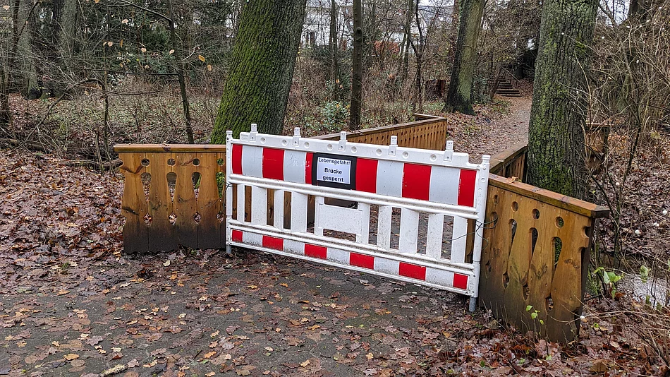 Fußgängerbrücke am "Haus Togohof" ist einsturzgefährdet und deshalb gesperrt Vor einer Brücke steht eine rot-weiße Absperrung mit der Aufschrift "Lebensgefahr! Brücke gesperrt"