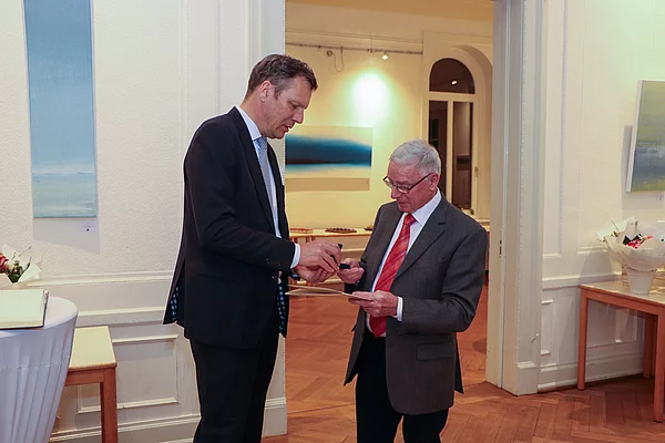 Bürgervorsteher Peters überreicht Paul Nowatzki eine goldene Ehrennadel.