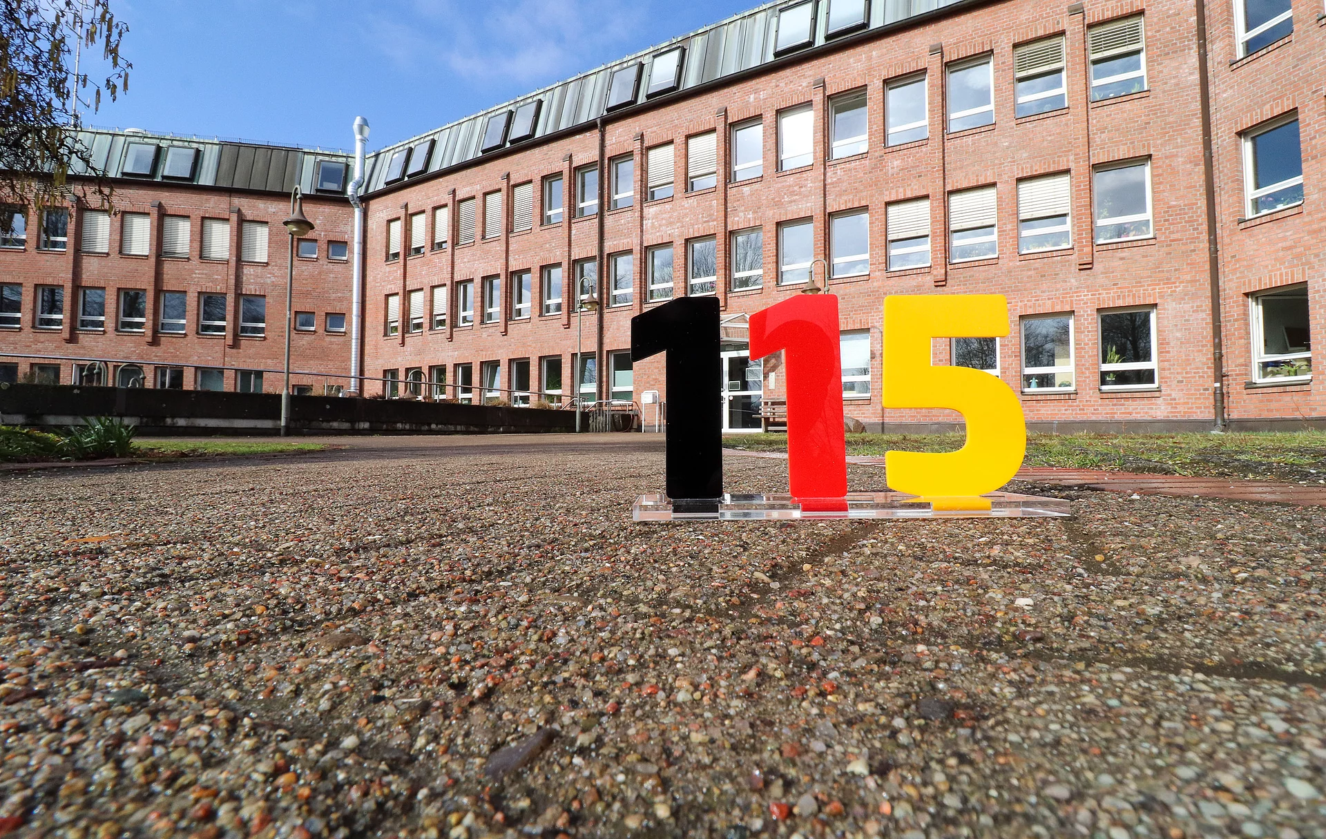 Vor dem Glinder Rathaus stehen die Zahlen 115, die auf die einheitliche Behördennummer 115 aufmerksam machen.