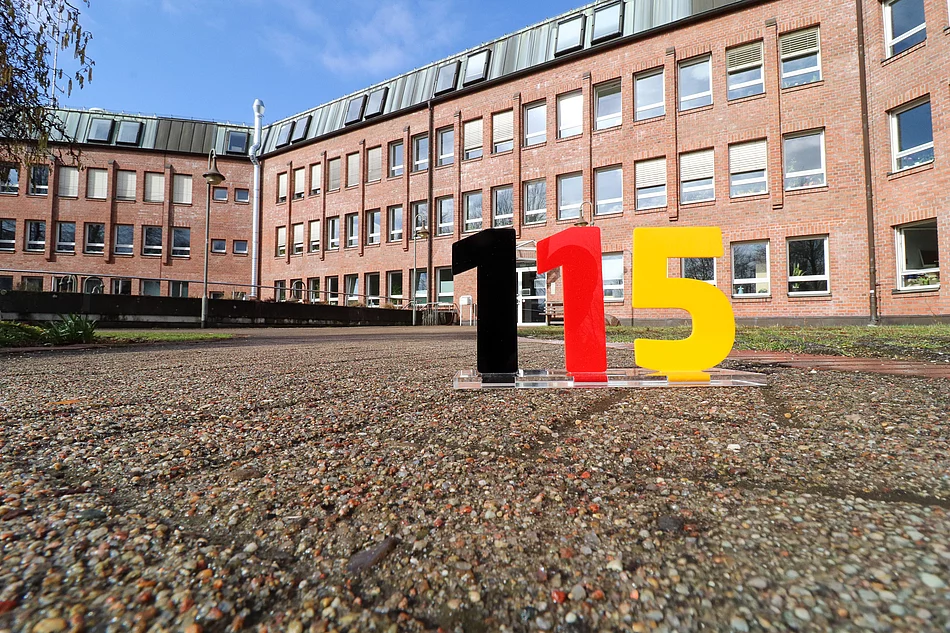 Vor dem Glinder Rathaus stehen die Zahlen 115, die auf die einheitliche Behördennummer 115 aufmerksam machen.